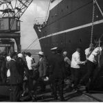 Pasażerowie przy statku; widoczne osoby wchodzące na statek po trapie